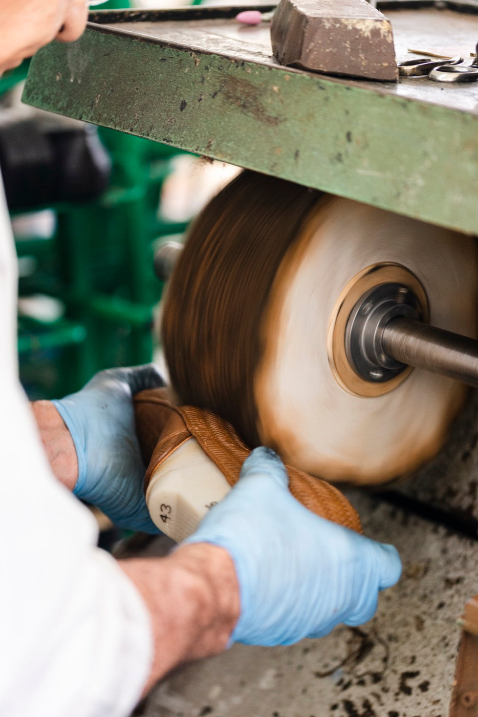 Hands at the polishing wheel in the atelier